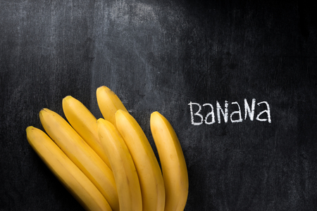 Top view image of fruit banana over dark chalkboard backgroundの写真素材