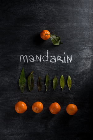 Top view photo of tangerines over dark chalkboard backgroundの写真素材