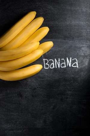 Top view image of fruit banana over dark chalkboard backgroundの写真素材