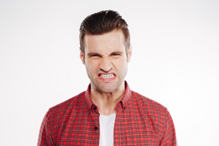 Close up portrait of Angry man in red shirt which looking at camera. Isolated white backgroundの写真素材