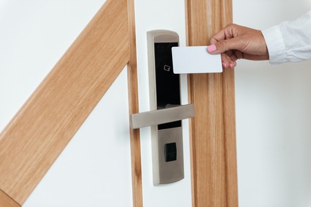Woman hand opening hotel room door with key card