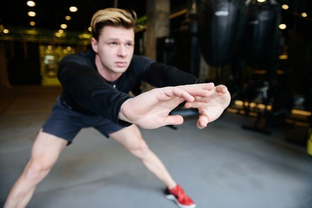 Concentrated Athletic man which warming up in gymの写真素材