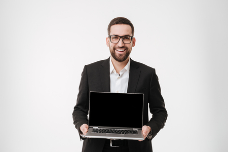Picture of young cheerful businessman over white background showing display of laptop computer.の写真素材
