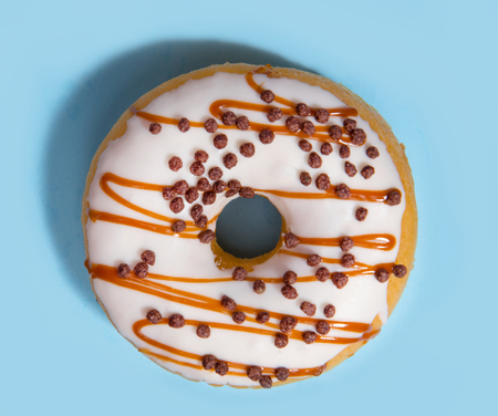 Top view photo of one colorful sweeties donut over blue table background.の写真素材