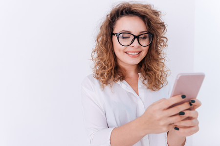 Smiling Woman in glasses and white shirt making selfie over gray backgroundの写真素材