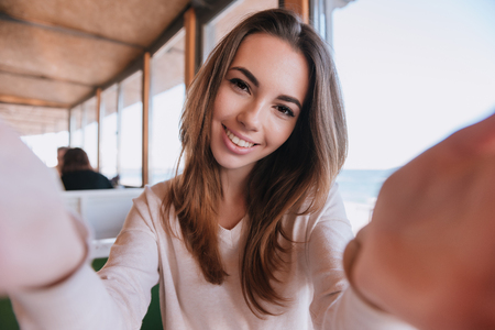 Happy Woman on date touching cheeks her man in cafe near the sea. First-person viewの写真素材