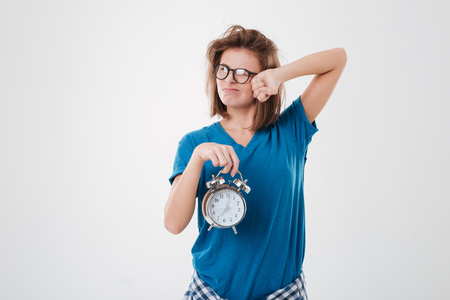 Portrait of a tired overslept girl with messy hair over white backgroundの写真素材