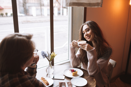Image of loving couple sitting at the table in cafe while looking at each other.の写真素材