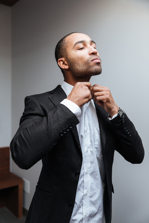 Vertical image of African man in suit buttons shirt in hotelの写真素材