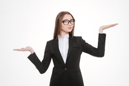 Young business woman holding hands like a libra isolated on a white backgroundの写真素材