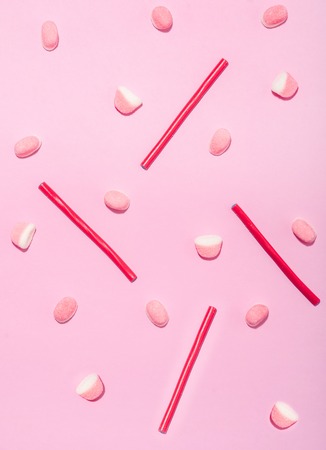 Pattern made of red licorice sweets and lollies isolated on pink background