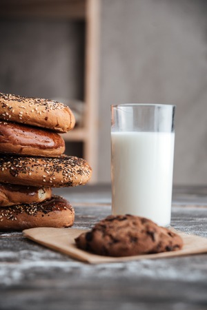 Image of pastries on dark wooden table with milk and cookie at bakeryの写真素材