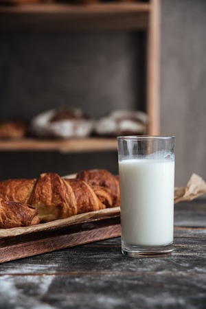 Photo of pastries on dark wooden table with milk at bakeryの写真素材