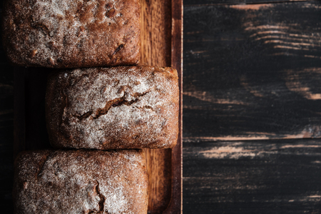 Image of bread with flour on dark wooden table background at bakery