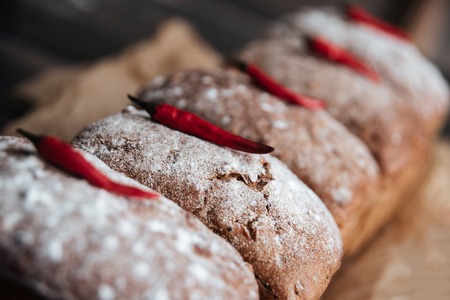 Picture of bread with flour and pepper on dark wooden table at bakeryの写真素材