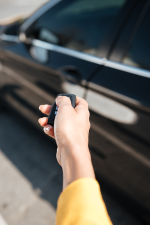 Closeup of woman hand holding keys and closing the door of her carの写真素材