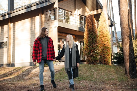 Photo of smiling loving couple walking outdoors in the forest. Looking aside.の写真素材