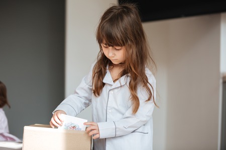 Little child getting out of package postcardsの写真素材