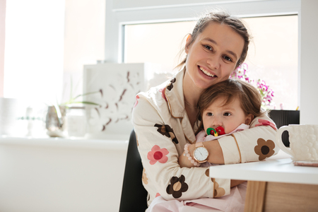Beautiful young mother hugging her little child with nippleの写真素材