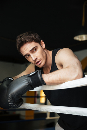 Picture of young strong boxer training in a boxing ring. Looking aside.の写真素材