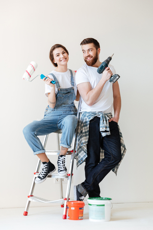 Picture of young happy loving couple sitting indoors in new flat and make repair.の写真素材