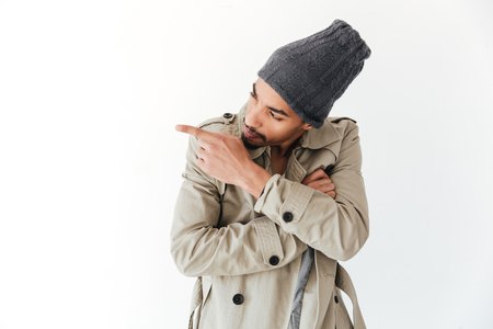 Picture of handsome young african man isolated over white background. Looking aside and pointing.の写真素材
