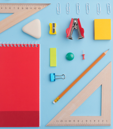 Top view picture of office supplies on the blue background table