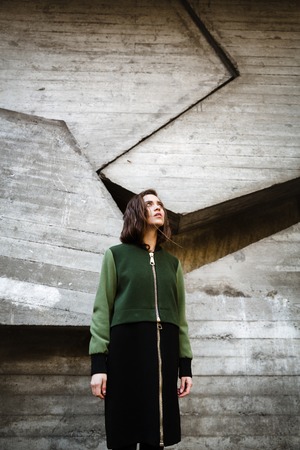 Image of pretty young woman standing and posing outdoors. Looking aside.の写真素材