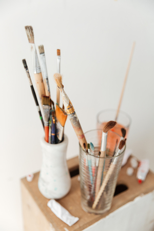 Image of painting brushes over white wall.の写真素材