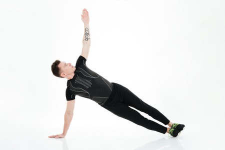 Image of handsome strong sportsman make sports exercises isolated over white background. Looking aside.の写真素材