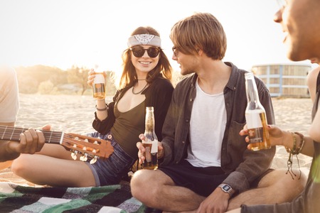 Group of friends hanging out with beer at the beachの写真素材