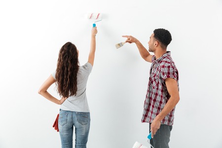 Back view of man and woman making repair isolated over whit backgroundの写真素材