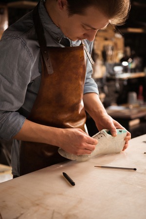 Close up of a man shoemaker working at a workshopの写真素材