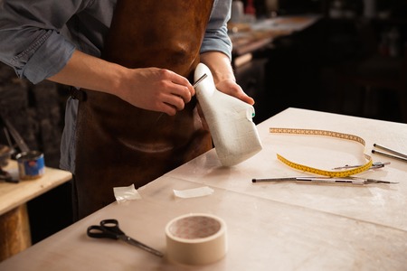 Close up of a cobbler modeling mens shoe at his workshop