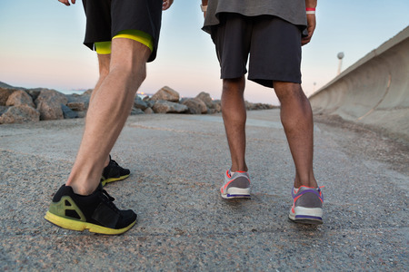 Back view of two male runners in sneakers outdoorsの写真素材
