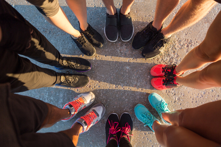 Top view of runners standing in a huddle with their feet togetherの写真素材