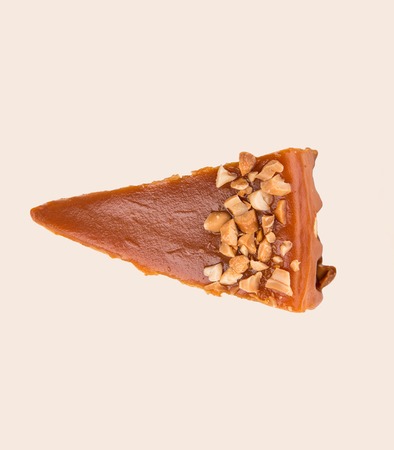 Shot of caramel cheesecake with nuts isolated over whiteの写真素材