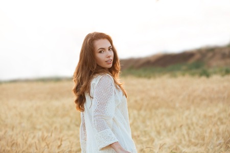 Attractive young girl posing while standing outdoors and looking at cameraの写真素材