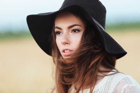 Picture of gorgeous young woman standing in the field. Looking aside.の写真素材