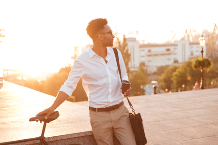 Image of concentrated young african man early morning with bicycle outdoors. Looking aside.の写真素材