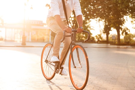 Cropped picture of handsome young african man early morning with bicycle walking outdoors.の写真素材