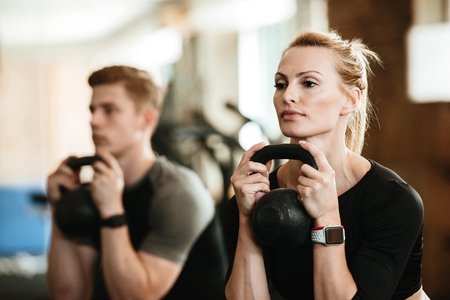 Picture of group of multiethnic sports strong people make sport exercise with weight. Looking aside.の写真素材