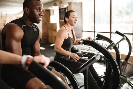Picture of group of multiethnic sports strong people make sport exercise with spinning bicycles.