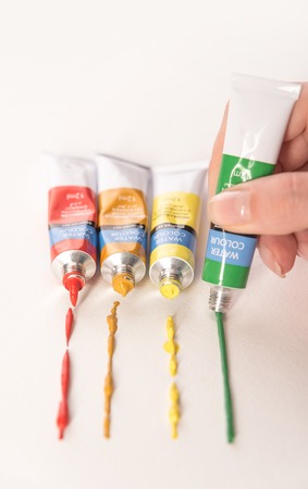 Tubes with watercolor paints of differnt colours making trace isolated over white backgroundの写真素材