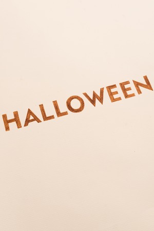 Decorated orange typeface text for halloween logo with traditional symbols handwritten on white background,の写真素材