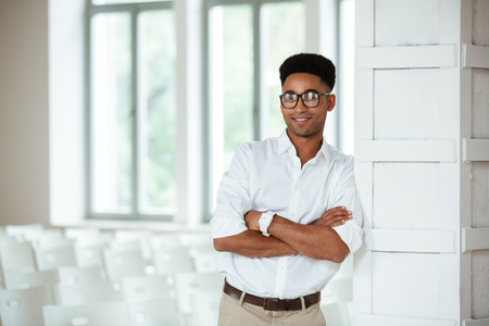 Picture of cheerful young handsome african man standing in office. Looking camera.の写真素材