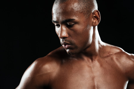 Afro american sports man, resting after workout, looking away, isolated on black background