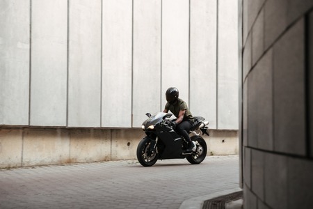 Portrait of a young afro american man in helmet riding motorbike outdoorsの写真素材