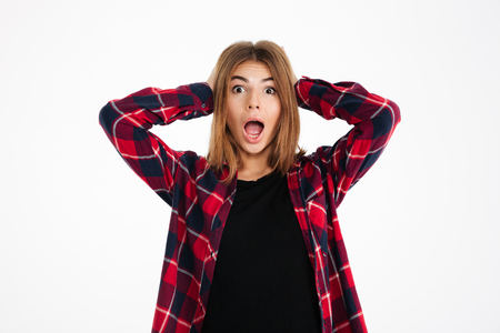 Photo of shocked young woman standing isolated over white wall background. Looking camera.の写真素材