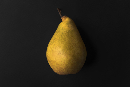 Close up of a fresh pear isolated over black backgroundの写真素材